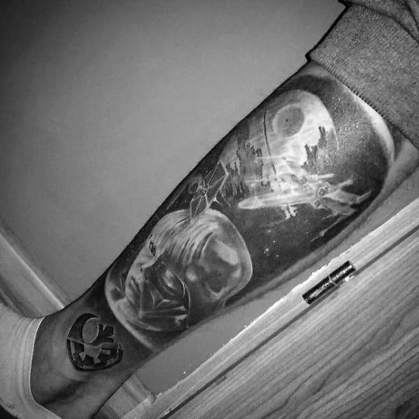 Black and white tattoo of the Death Star with space-themed imagery on a person's leg