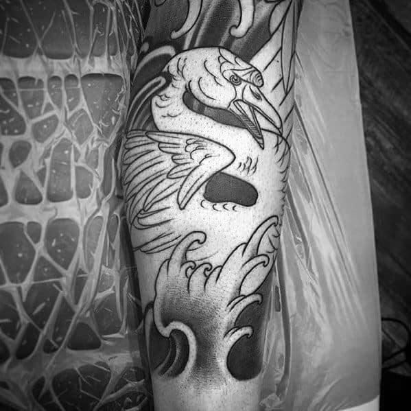 Bold black and grey swan tattoo with dynamic waves and traditional shading, capturing movement and strength in a classic style.