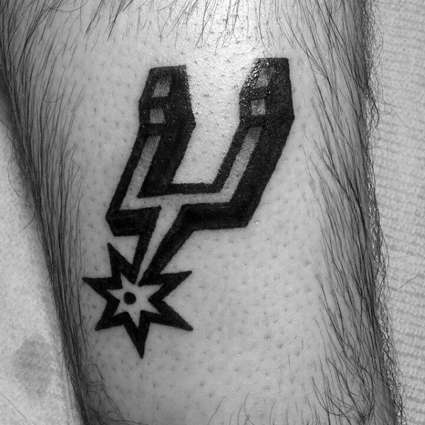 Bold black San Antonio Spurs logo tattoo on the leg, featuring sharp lines and a clean, solid fill for a strong, graphic look.