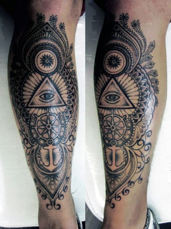 Ornate leg tattoo featuring an eye inside a triangle, anchor, and intricate patterns