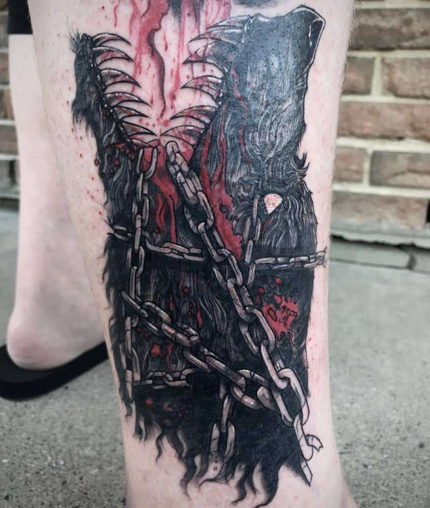 This tattoo showcases a powerful Norse wolf design, its fur intertwined with broken chains and splashes of red, symbolizing rebellion and ferocity