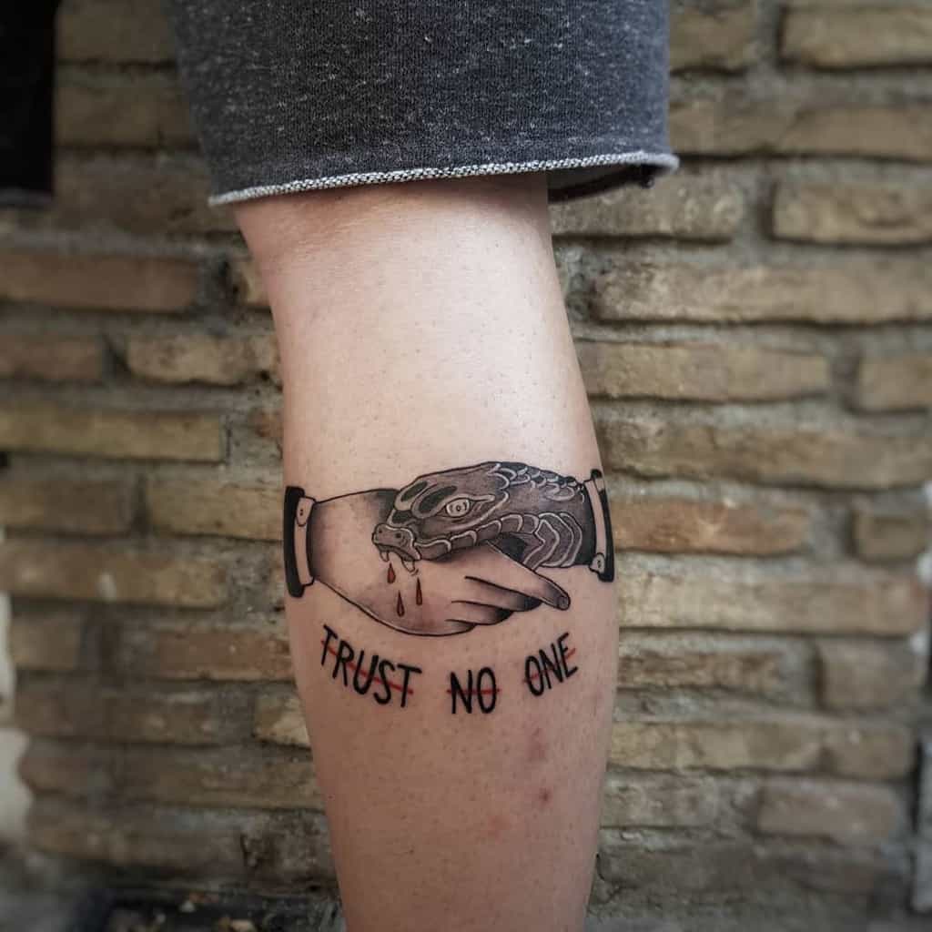 Tattoo of a snake biting a hand with "Trust No One" text on a calf