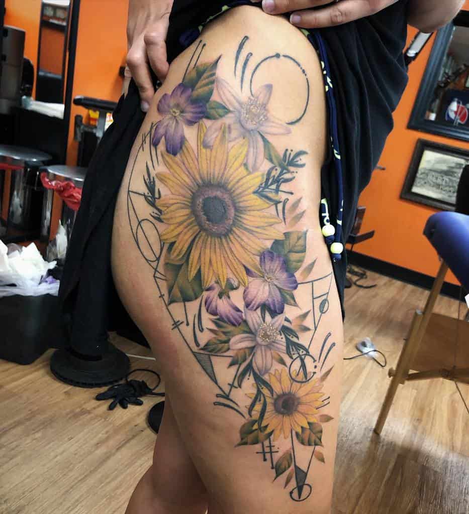 Large tattoo featuring vibrant sunflowers and delicate violet flowers intertwined with geometric and abstract linework for a dynamic design