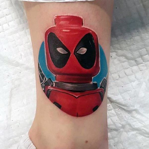 Bold tattoo of Lego Deadpool’s upper body with dual katanas on his back, set against a vibrant blue circular background.