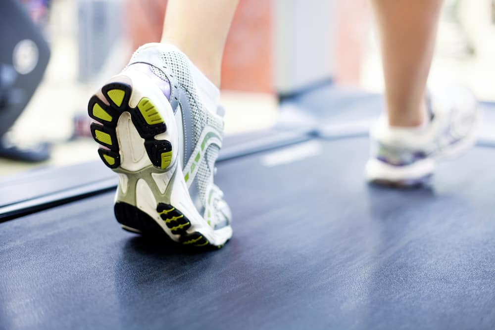 women legs on treadmill with white shoes