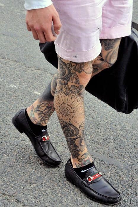 Legs with intricate floral and geometric tattoo designs