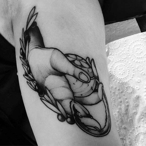 Black and grey tattoo of a hand squeezing a lemon with juice flowing, surrounded by leaves and shaded in a realistic style.