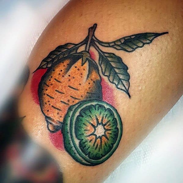 Bold tattoo of a lemon and sliced kiwi with green leaves, set against a red background, done in a vibrant traditional style.