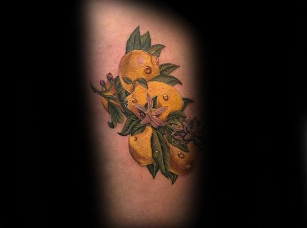 Realistic tattoo of a lemon cluster with detailed leaves and blossoms, featuring rich colors and soft shading for a lifelike effect.