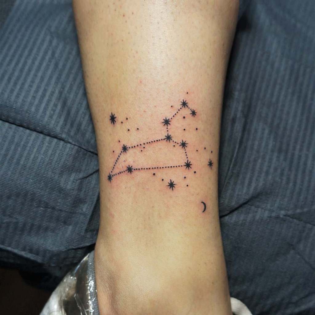 Black ink Leo constellation tattoo on the lower leg, blending astrology with subtle cosmic details.