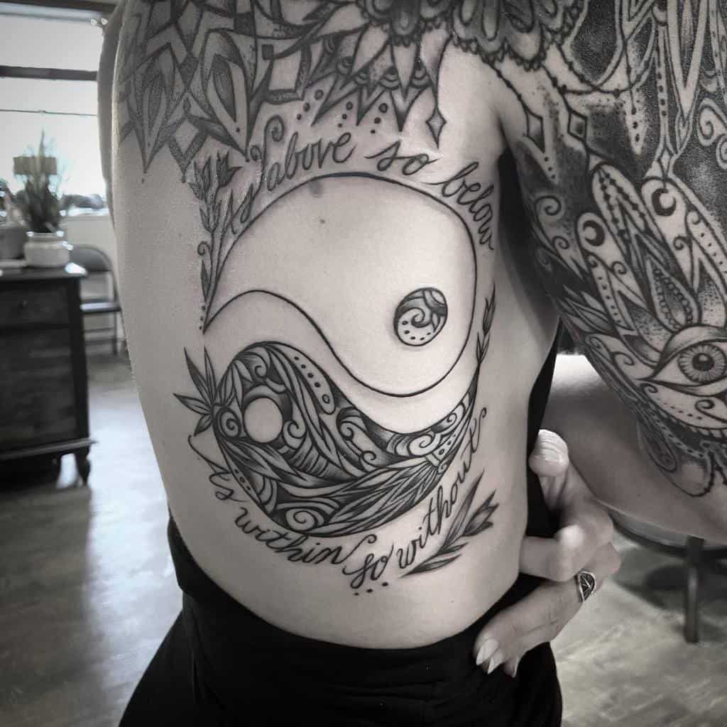 Intricate rib tattoo combining the phrase 'As Above So Below' with a detailed yin-yang symbol, blending cosmic balance and artistic elegance