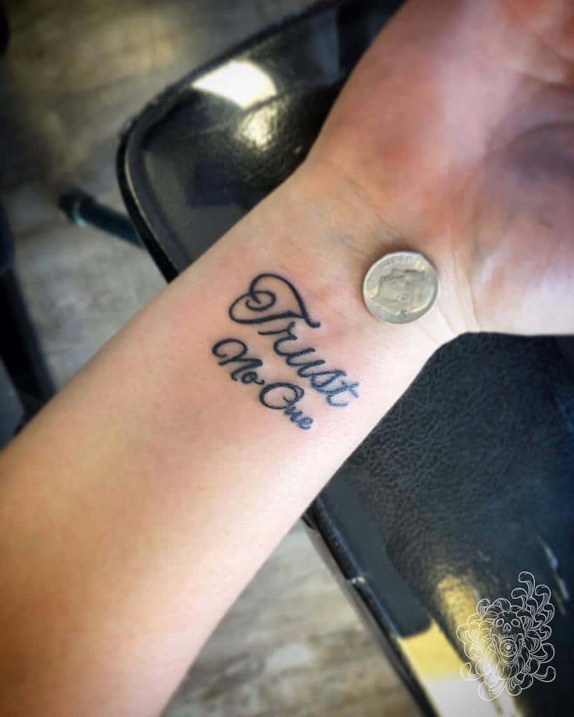 Wrist tattoo that reads "Trust No One"