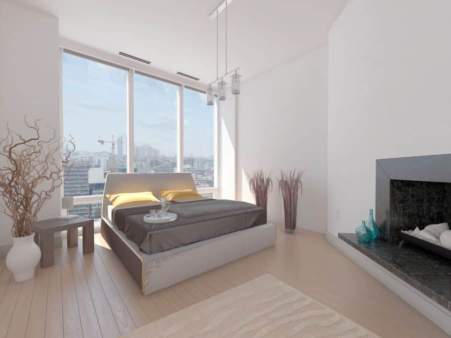 Modern apartment bedroom featuring a fireplace, city view, and elegant decor.