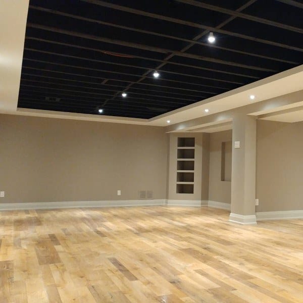 Spacious basement with recessed lighting, black ceiling accents, and light hardwood floors.