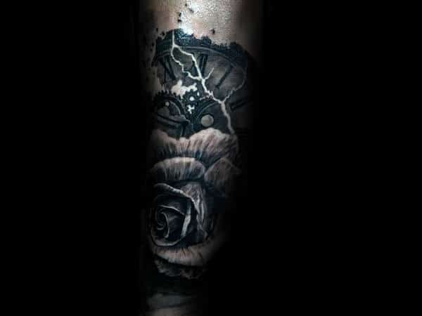 Black and white tattoo of a rose with a cracked clock and gears above it