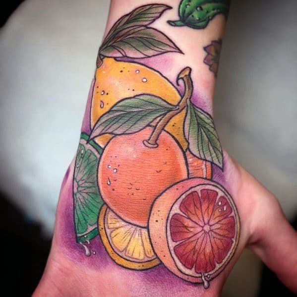 Vibrant citrus fruit tattoo featuring oranges, blood oranges, and a lime slice, with bold colors and detailed shading for a fresh, dynamic design.