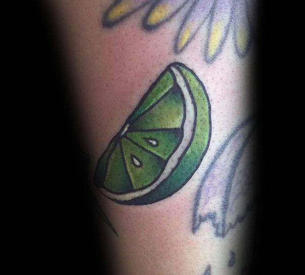 Bold lime wedge tattoo with vibrant green shading and crisp white highlights, creating a fresh and dynamic citrus-inspired design.
