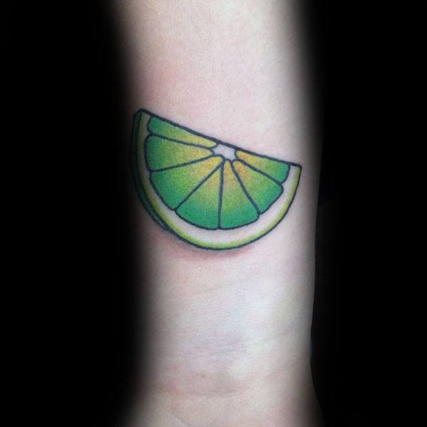 Vibrant lime wedge tattoo with bold green and yellow shading, featuring clean lines for a fresh and minimalist citrus-inspired design.
