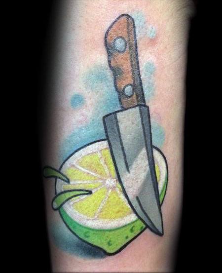 Bold lime and knife tattoo with vibrant green and yellow shading, featuring juice splashes and a rustic knife for a dynamic citrus-inspired design.