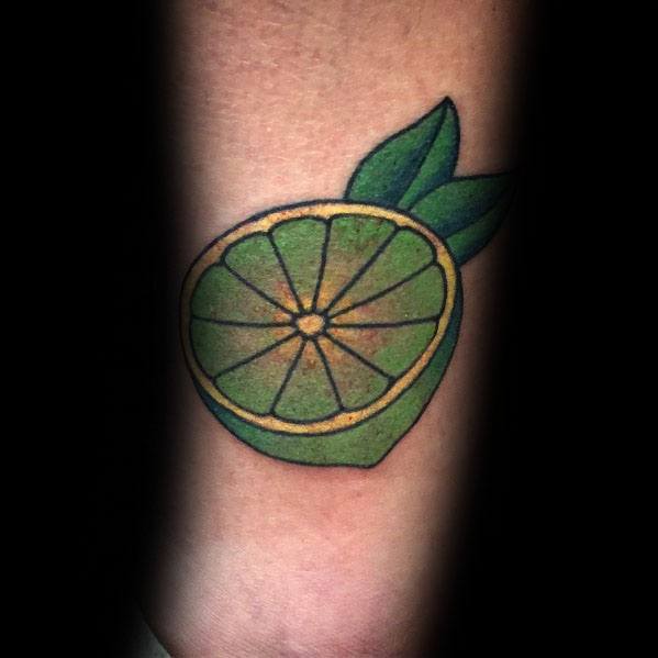 Bold lime tattoo with vibrant green shading and leaf accents, creating a fresh and classic citrus-inspired design.