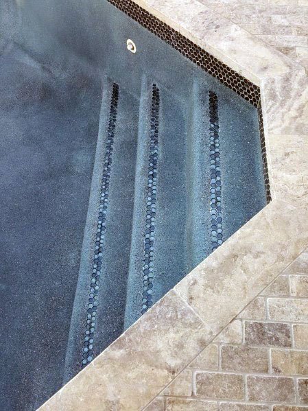 Elegant pool stairs featuring a limestone surround with iridescent accent tiles on each step for a sophisticated touch.