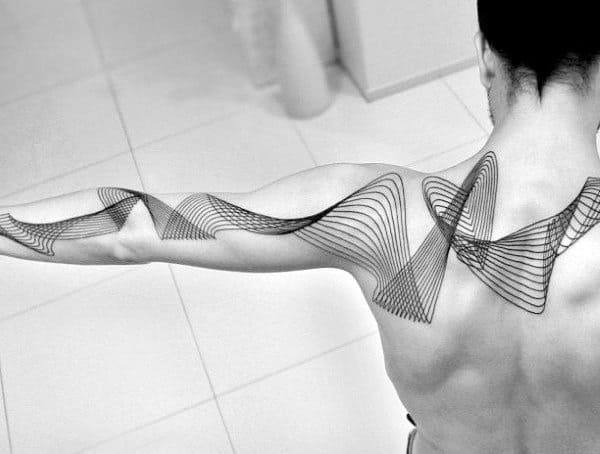 Minimalist geometric tattoo with flowing black linework, creating an abstract wave-like pattern across the shoulder and arm.