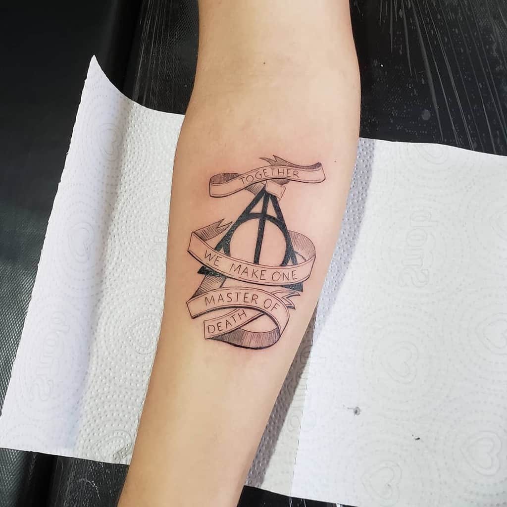 Deathly Hallows tattoo with a ribbon wrapping around, featuring the quote 'Together we make one master of death