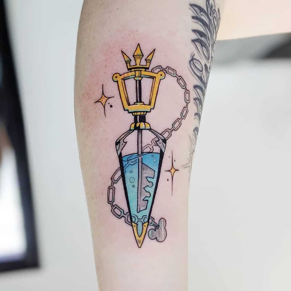 Colorful Kingdom Hearts tattoo featuring a Keyblade-shaped potion bottle with a glowing blue liquid and chain details on the forearm.