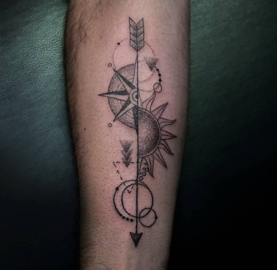 Forearm tattoo featuring an arrow with geometric sun, moon, and compass elements, symbolizing balance, direction, and cosmic harmony.
