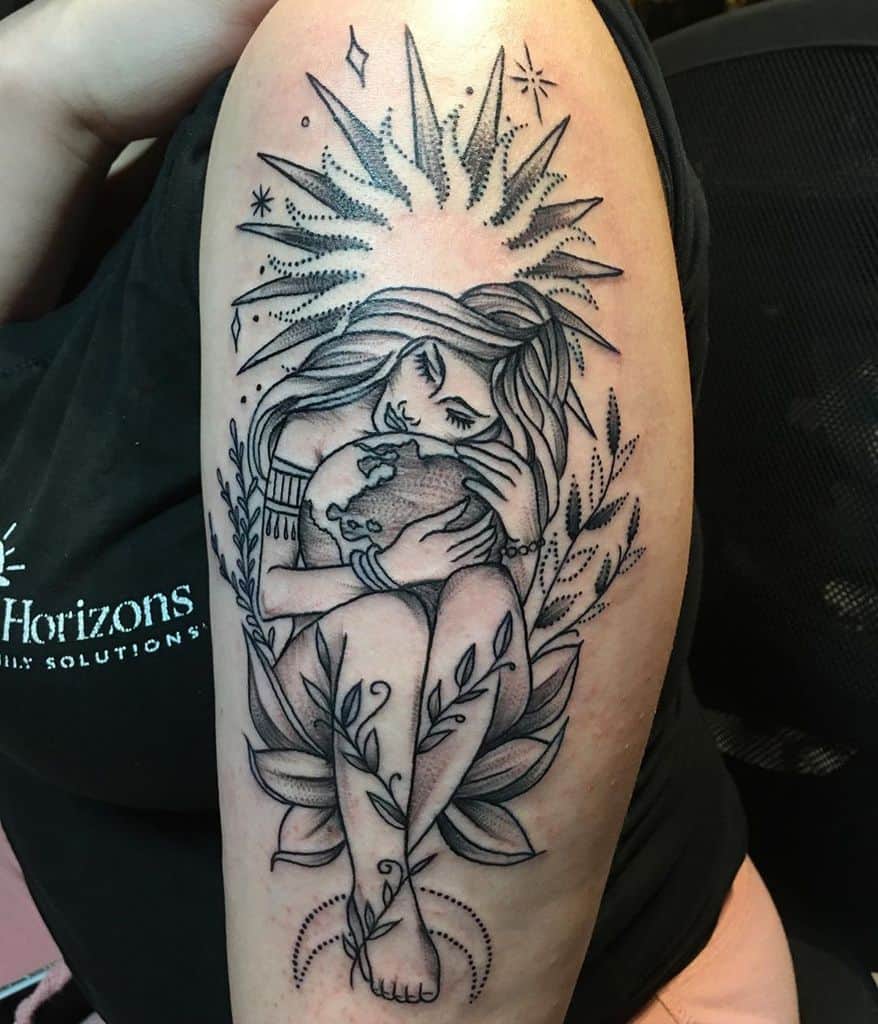 Black ink tattoo of a woman embracing the Earth, sitting on a lotus with celestial elements and sun rays radiating above her.