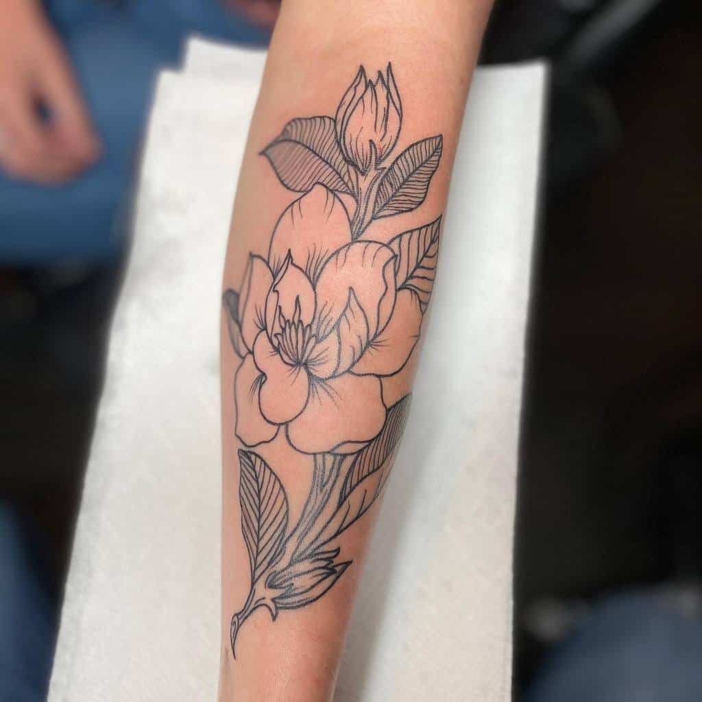Arm tattoo featuring large magnolia flowers and leaves in stunning black ink