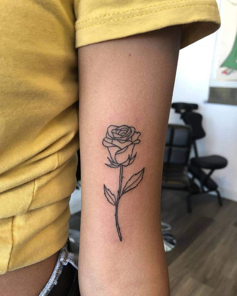 Line art rose tattoo on an arm