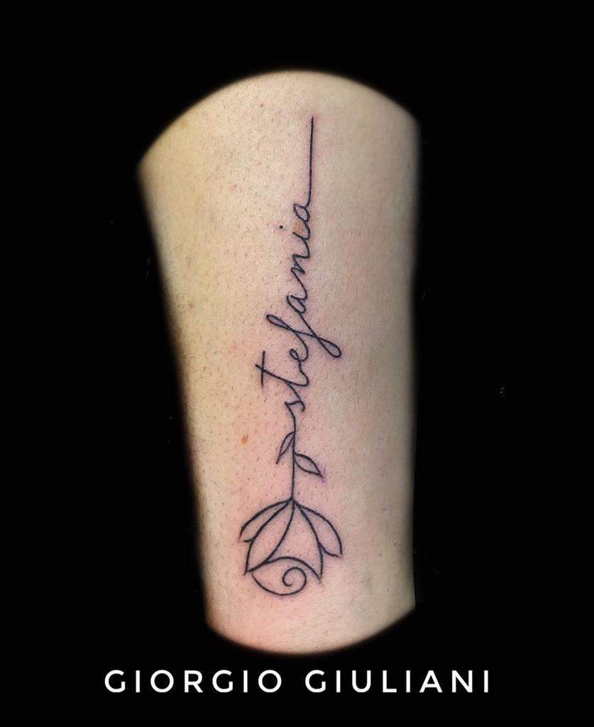 Tattoo of the name "stefania" with a rose design underneath