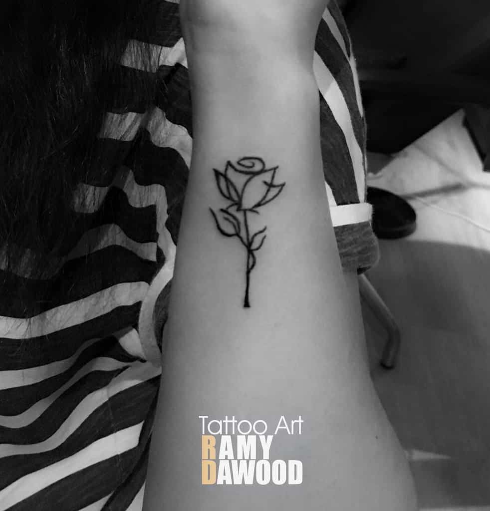 Minimalist rose tattoo on a forearm