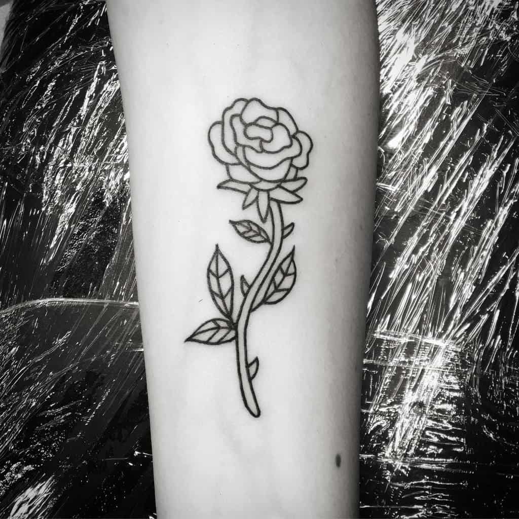 Minimalist black line rose tattoo on an arm