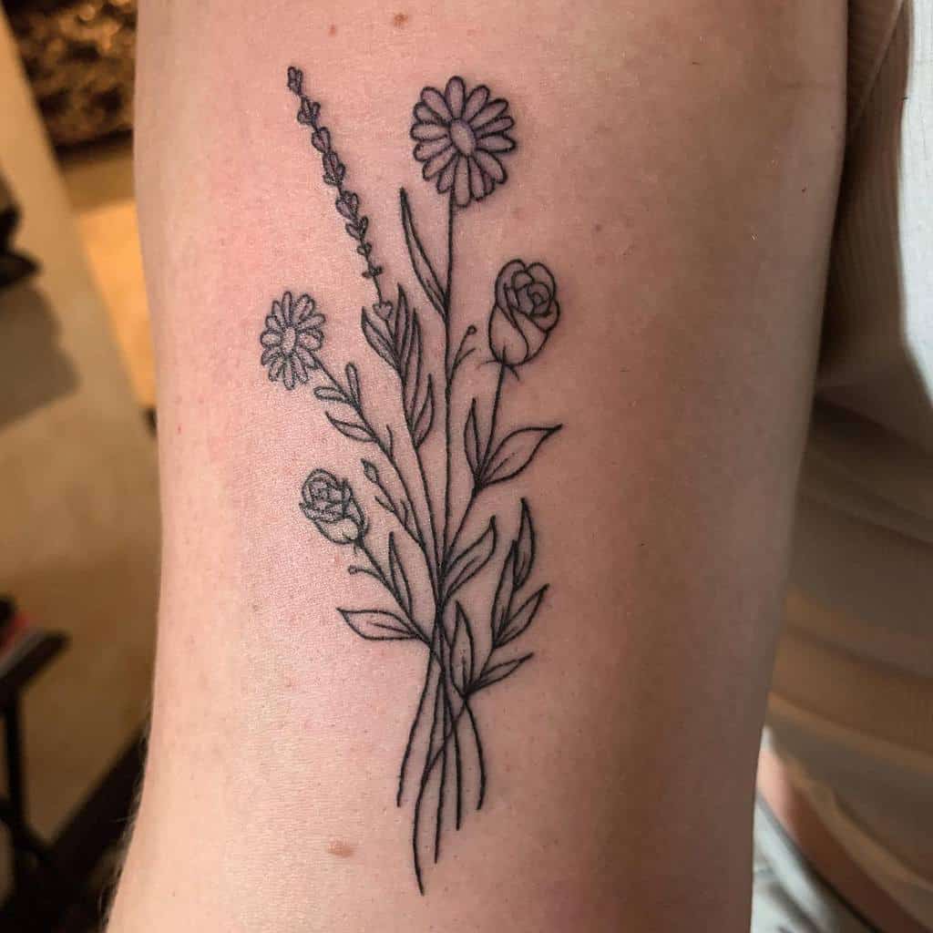 Line art flower tattoo on upper arm, featuring daisies and roses