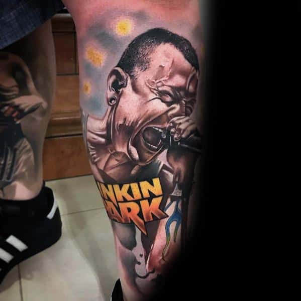 Vivid color tattoo of Chester Bennington screaming, featuring a bold Linkin Park logo and dynamic shading on the leg.