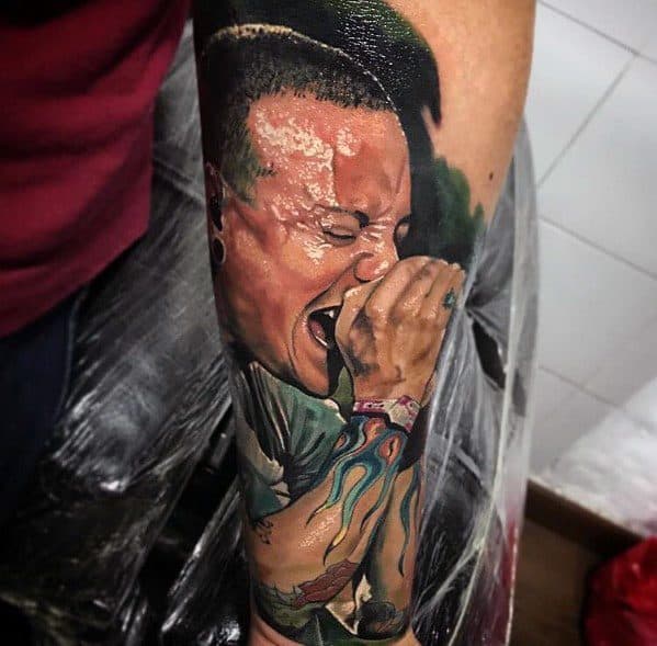 Vivid color tattoo of Chester Bennington mid-performance, capturing his raw energy with intense facial expression and detailed tattoo sleeve.