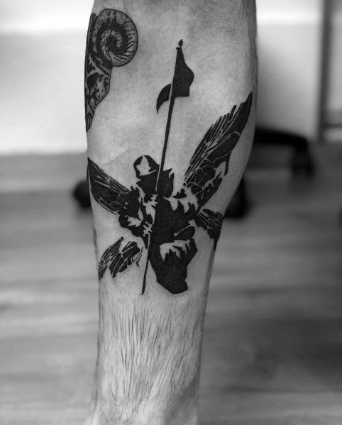 Bold black Linkin Park Hybrid Theory soldier tattoo on the leg, featuring a solid silhouette design with detailed wings and a flag.