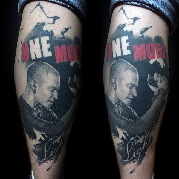 Black and gray tattoo of Chester Bennington with 'One More Light' in bold red and white lettering, honoring his legacy.