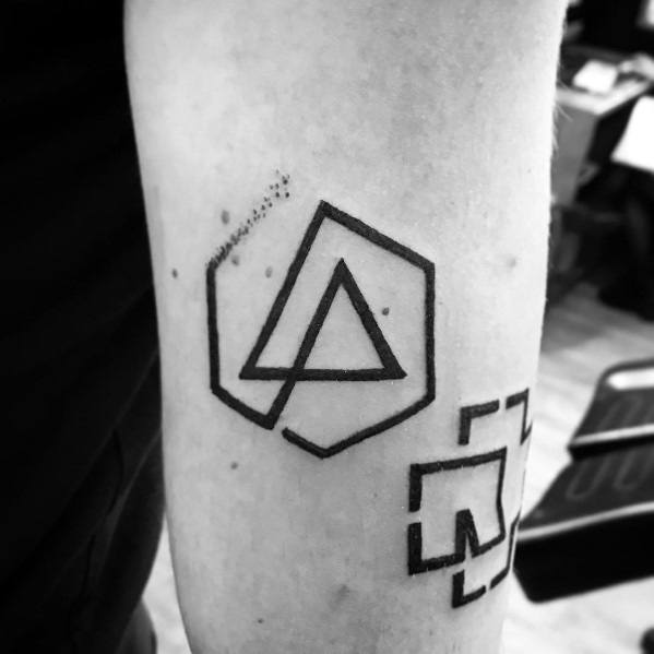 Minimalist black ink Linkin Park logo tattoo with geometric elements and a subtle pixelated effect on the forearm.