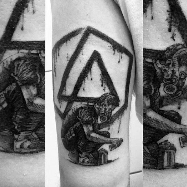 Black and gray tattoo featuring the Linkin Park logo with a graffiti artist in a gas mask, capturing a raw and urban aesthetic.