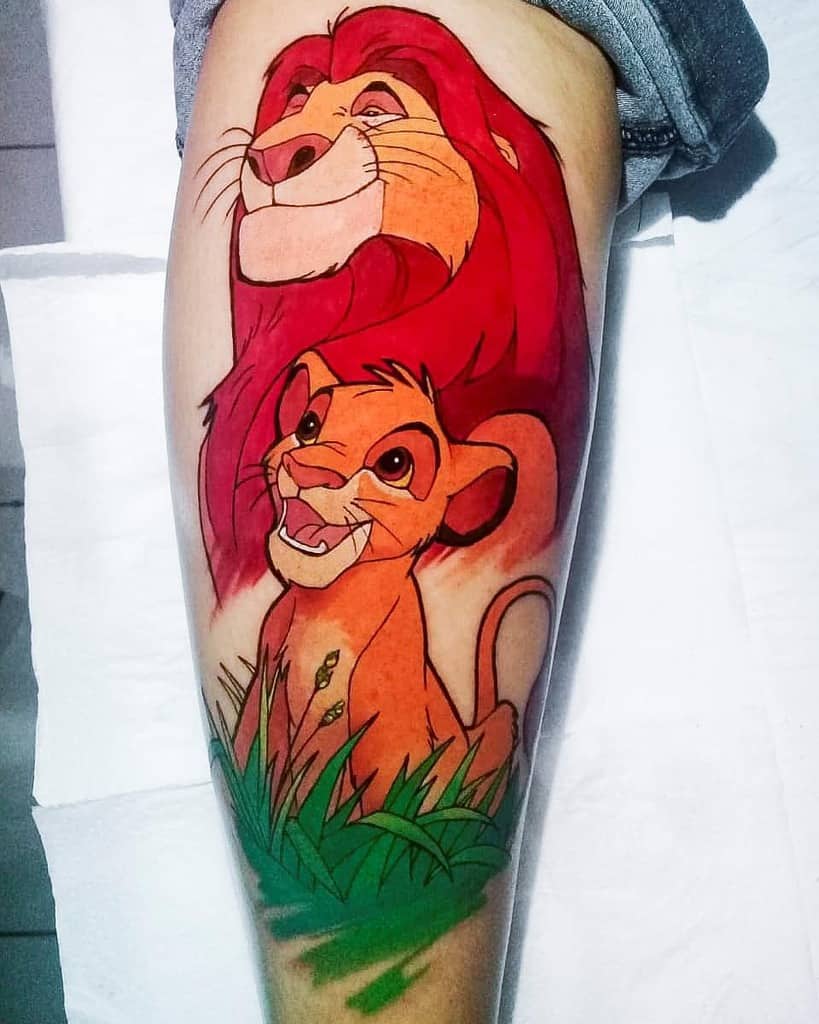 Vibrant tattoo of Simba and his father Mufasa, showing their joyful expressions with grass details below, symbolizing their strong bond