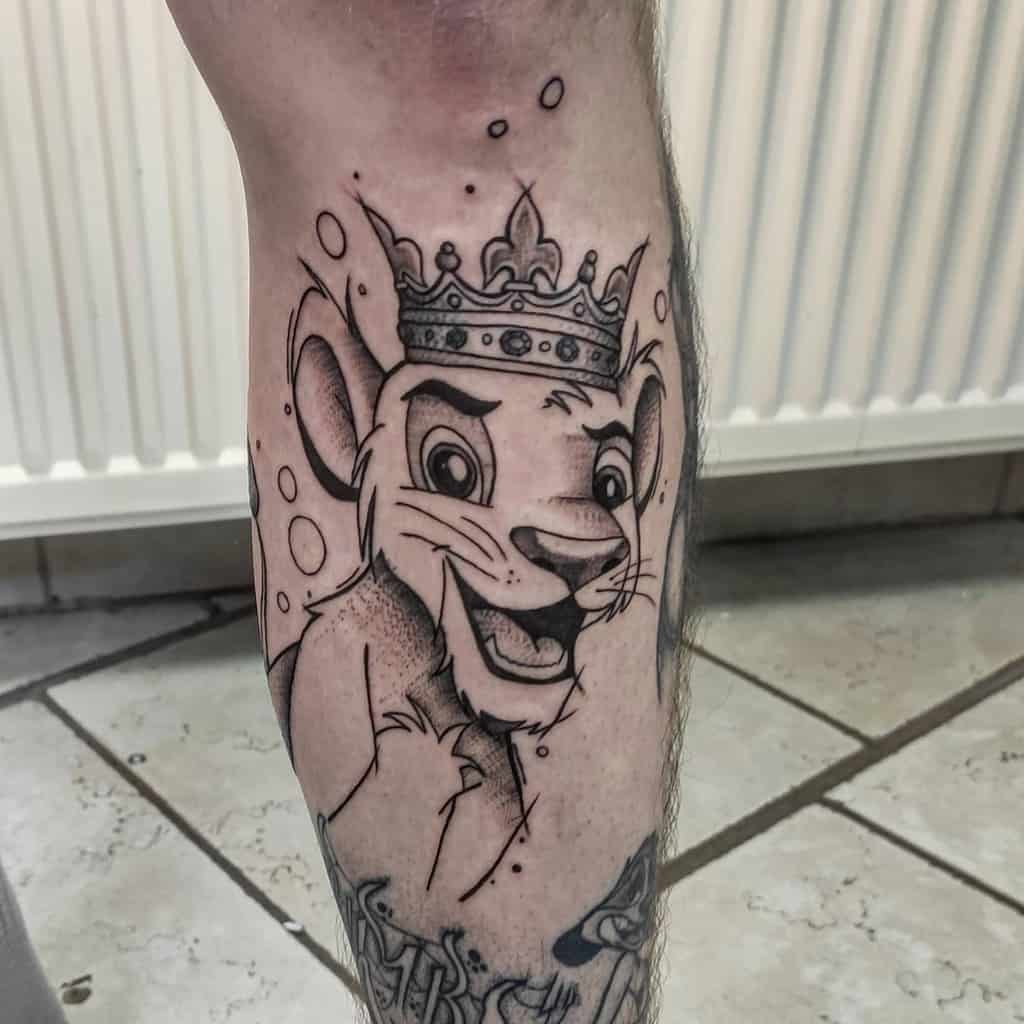 Black and white tattoo of Simba with a crown on his head, symbolizing his journey to royalty with playful bubble accents