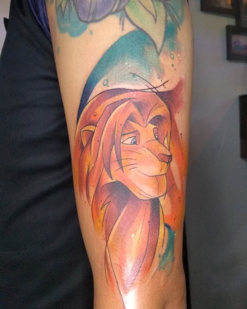 Colorful tattoo of Simba with flowing orange and blue hues around his face, symbolizing strength and wisdom with an artistic touch