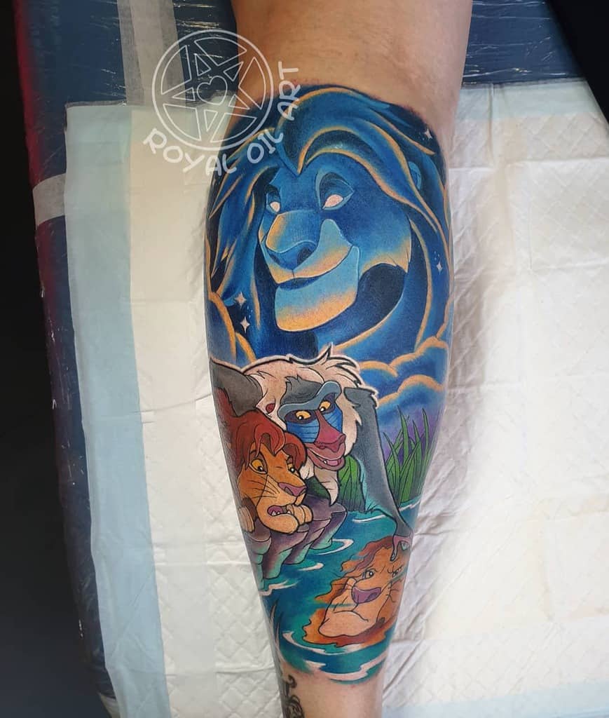 Vibrant tattoo with Simba, Mufasa as a glowing spirit, and Rafiki, symbolizing guidance and self-discovery with Simba’s reflection in water
