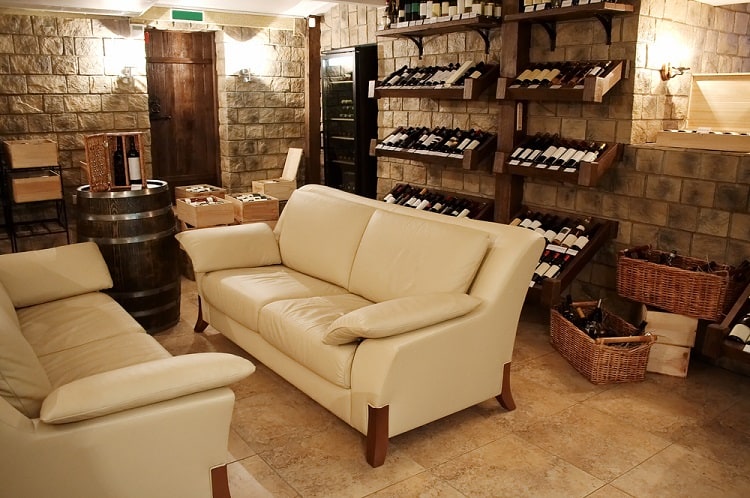 basement wine cellar wall wine racks beige sofa stone walls