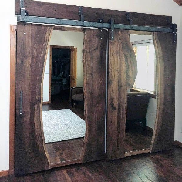 A unique barn-style sliding door made from live-edge wood slabs, adding a rustic touch with integrated mirrors for functional elegance