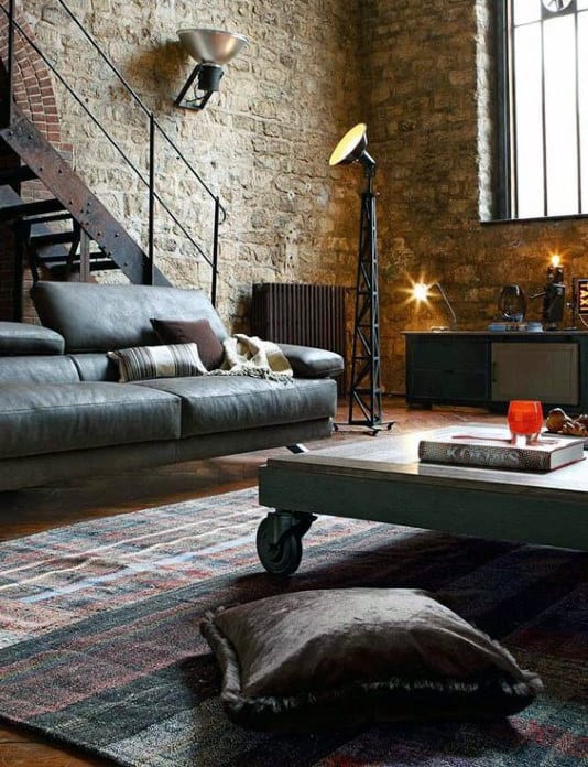 Contemporary living room with exposed brick walls, leather sofa, and industrial decor elements.