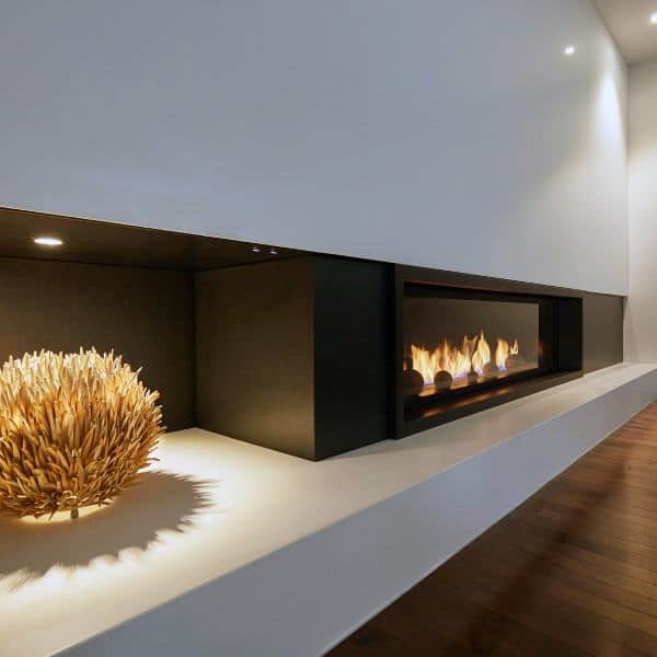 Modern linear gas fireplace with a black frame set into a minimalist white ledge.